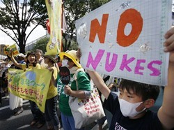 Anti-nuclear protesters carry "No nukes" banners during a march in Tokyo, Monday, July 16, 2012. 