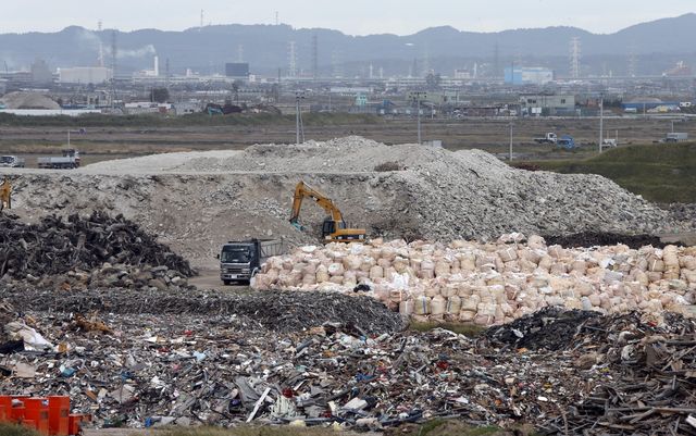 A crane this month sorts out rubble from the 2011 earthquake and tsunami at the collection site in northeastern  Japan. Some reports suggest the country's reconstruction efforts are set back by spending on unrelated projects. Credit: Koji Sasahara / Associated Press